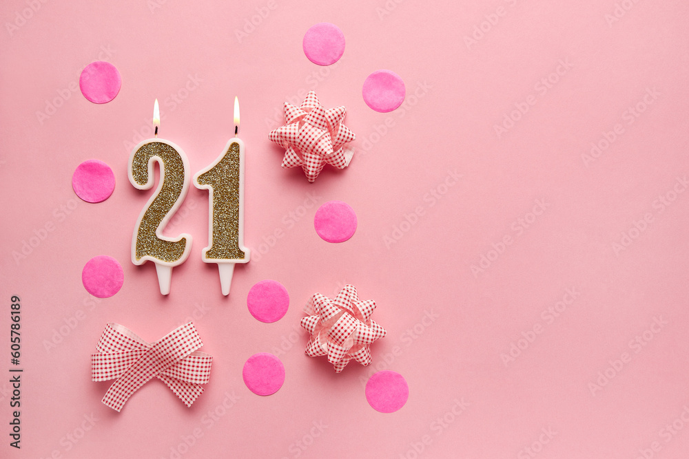 Number 21 on pastel pink background with festive decor. Happy birthday candles. The concept of celebrating a birthday, anniversary, important date, holiday. Copy space. Banner