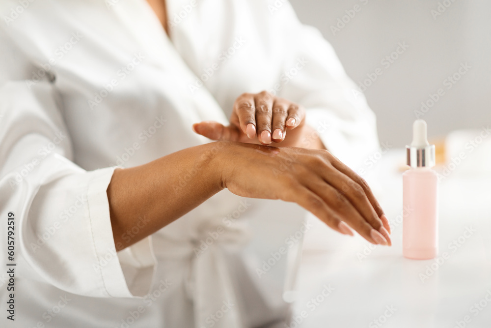 Skin Moisturizing. Black Woman Applying Nourishing Serum On Hands At Home Skin Moisturizing. Black Woman Applying Nourishing Serum On Hands At Home