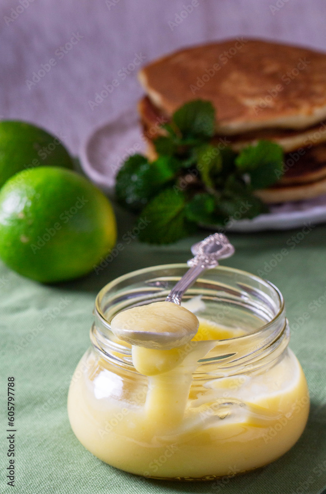 Custard lime curd served with pancakes on a light background. Rustic style.