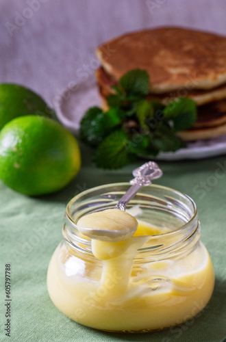 Custard lime curd served with pancakes on a light background. Rustic style.