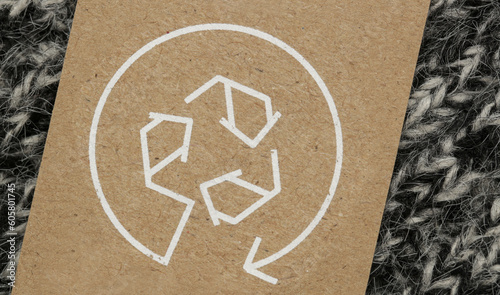 Close up of clothing tag with recycle icon. Recycling products concept. Zero waste, suistainale production, environment care and reuse concept.