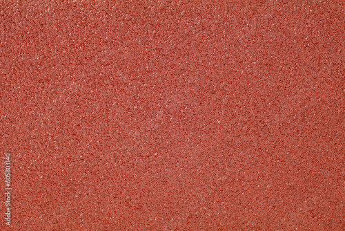 Background texture of sandpaper close-up, red granular homogeneous abrasive structure photo