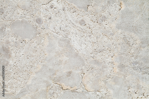 Background is beige marble slab with furrows from cuts, uniform texture