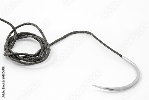 Surgical curved needle with thread, medical suture material, close-up, on white background
