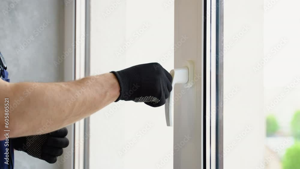Worker checks system of a window lock in hotel. The concept of protecting a child from falling out of windows. Handle with a lock on the window Worker checks system of a window lock in hotel. The concept of protecting a child from falling out of windows. Handle with a lock on the window