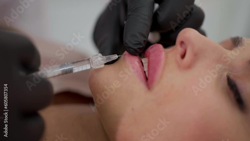 A cosmetologist performs a lip augmentation procedure in the salon.