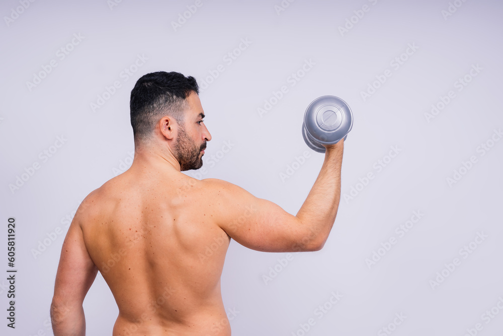 Athletic man doing exercises with dumbbell at biceps on white background. Strength and motivation Athletic man doing exercises with dumbbell at biceps on white background. Strength and motivation