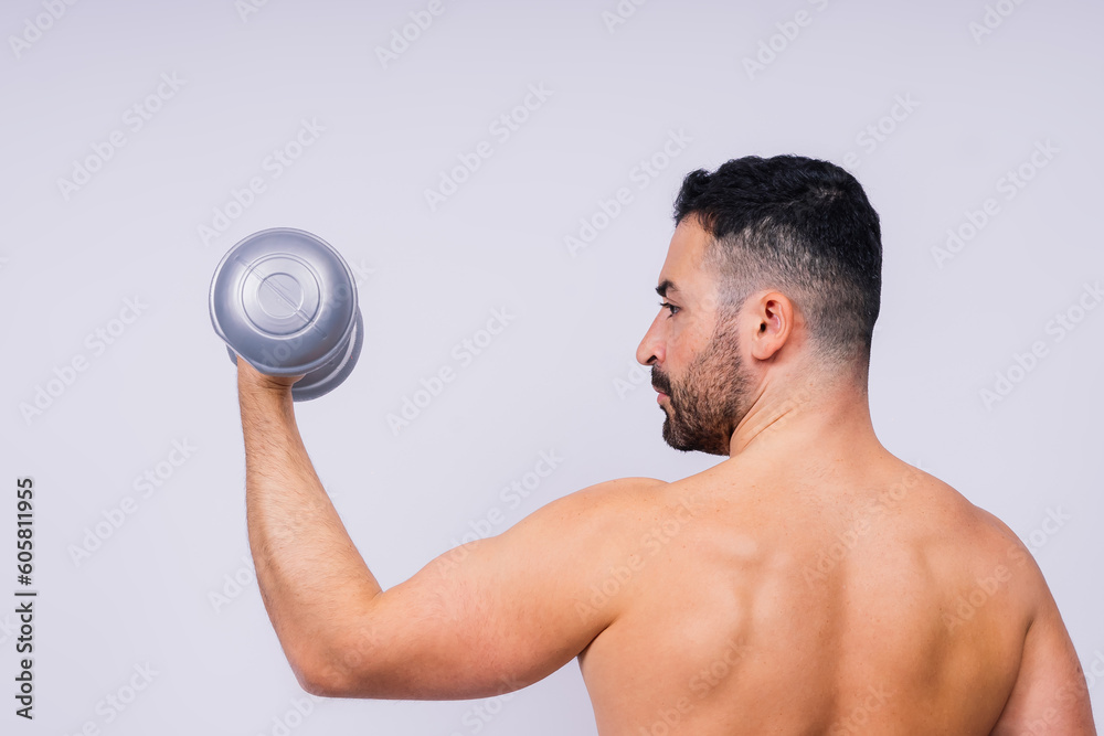 Athletic man doing exercises with dumbbell at biceps on white background. Strength and motivation Athletic man doing exercises with dumbbell at biceps on white background. Strength and motivation