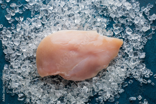 Foto Fresh chicken filet on ice with ingredients