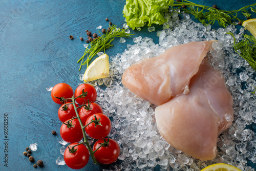 Fresh chicken filet on ice with ingredients