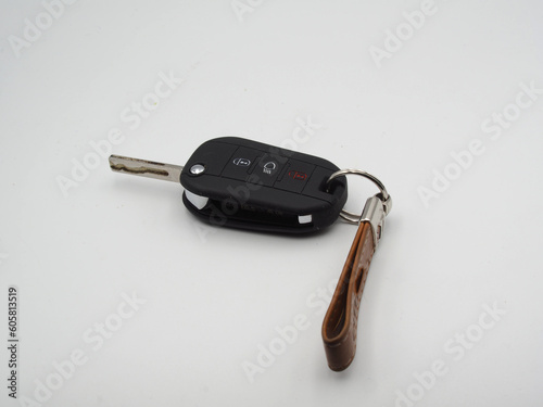 Car key in black leather case on white background