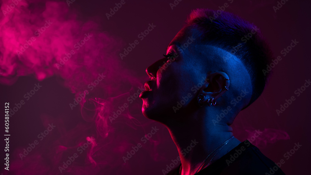 Profile Asian woman with short haircut smoking in neon light.