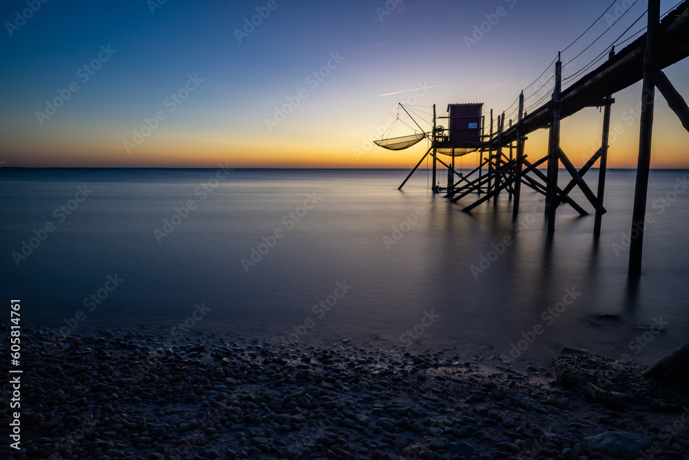 Fishing hut on stilts coast of Atlantic ocean at sunset near La Rochelle, Charente Maritime, France Fishing hut on stilts coast of Atlantic ocean at sunset near La Rochelle, Charente Maritime, France