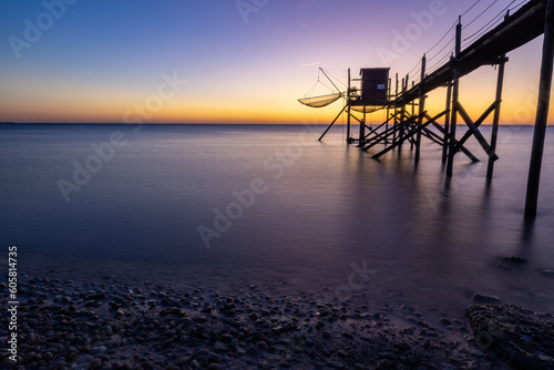 Fishing hut on stilts coast of Atlantic ocean at sunset near La Rochelle, Charente Maritime, France photo
