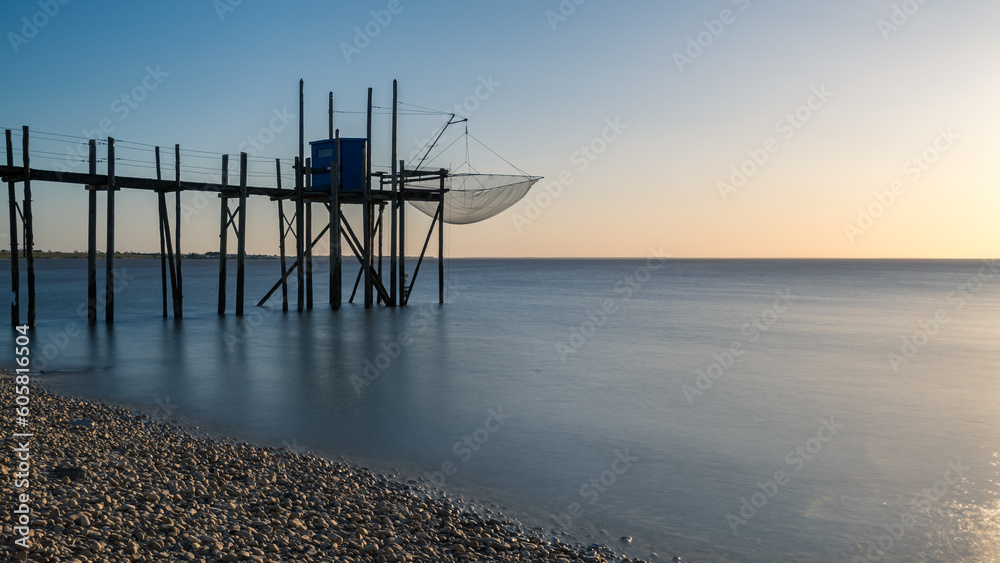 Fishing hut on stilts coast of Atlantic ocean at sunset near La Rochelle, Charente Maritime, France Fishing hut on stilts coast of Atlantic ocean at sunset near La Rochelle, Charente Maritime, France