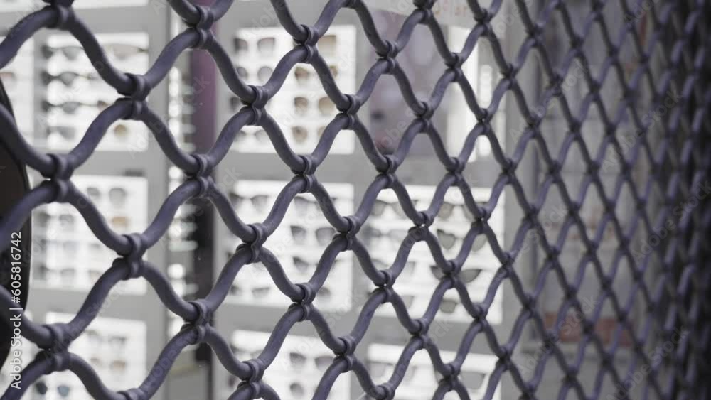 metal grid against blurred show window with sunglasses metal grid against blurred show window with sunglasses