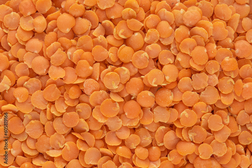 Red raw lentils in the whole frame. Vegetable protein. Horizontal photo.
