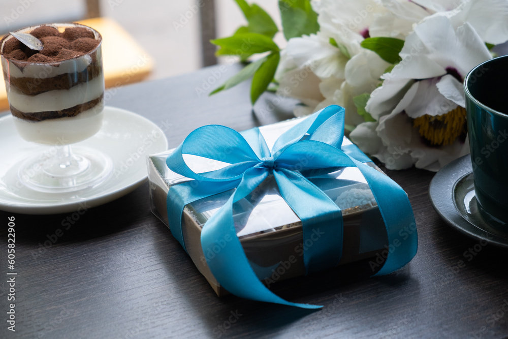 Gift box with chocolate craft candies on cafe table with cup and dessert. Sweet gift box Gift box with chocolate craft candies on cafe table with cup and dessert. Sweet gift box