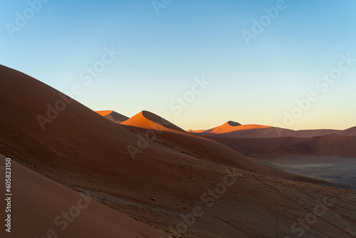 Fototapeta Naklejka Na Ścianę i Meble -  Majestätische Schönheit: Rote Sanddünen Afrikas  mit blauem Himmel - Die kraftvolle Pracht der Natur