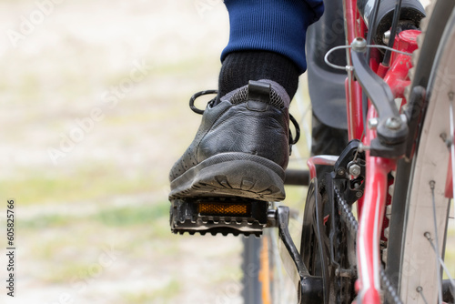 A cyclist's foot on a pedal, a close-up.A man's foot in a sneaker on a bicycle pedal.The concept of cycling, cycling.