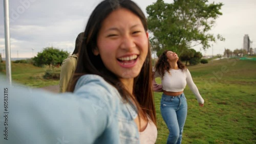 Young Asian girl filming having fun with friends on rain