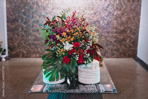 a flower arrangement on a table next to white china plates