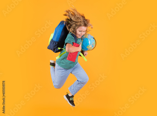 Kid jump and enjoy school. School boy in school uniform with backpack jumping on yellow isolated background. Kids learning knowledge and kids education concept.