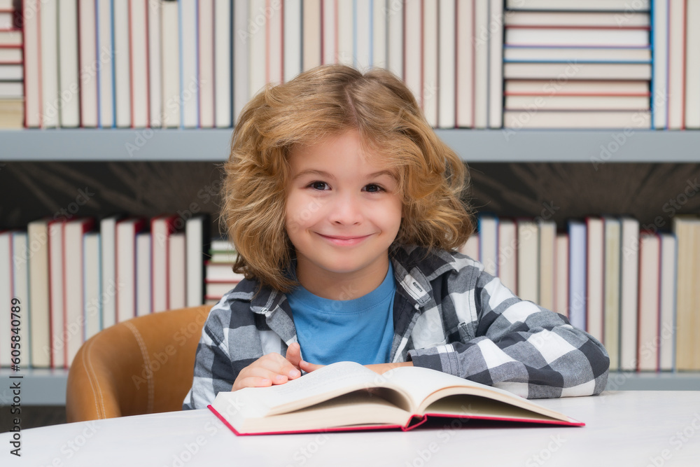 Education, knowledge and bookstore concept. Child in the library reads books. Schoolkid choosing book in school library. Kids literature for reading. Kid in bookstore. Education, knowledge and bookstore concept. Child in the library reads books. Schoolkid choosing book in school library. Kids literature for reading. Kid in bookstore.