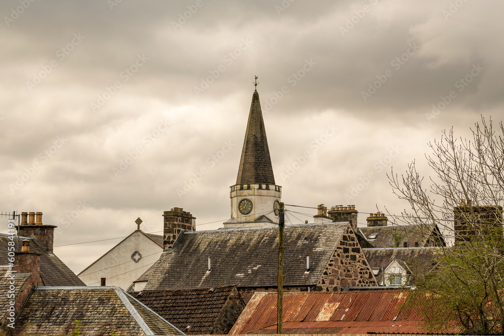 Fototapeta premium moody shot of roof lines and a church spire in a victorian era scottsih village somber heavy clouds