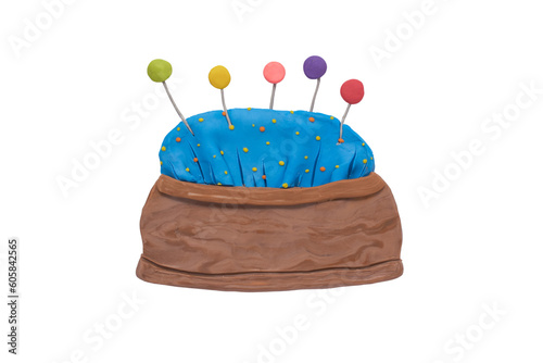 Needle cushion of the seamstress handmade with plasticine. Pin cushion full with colorful pins