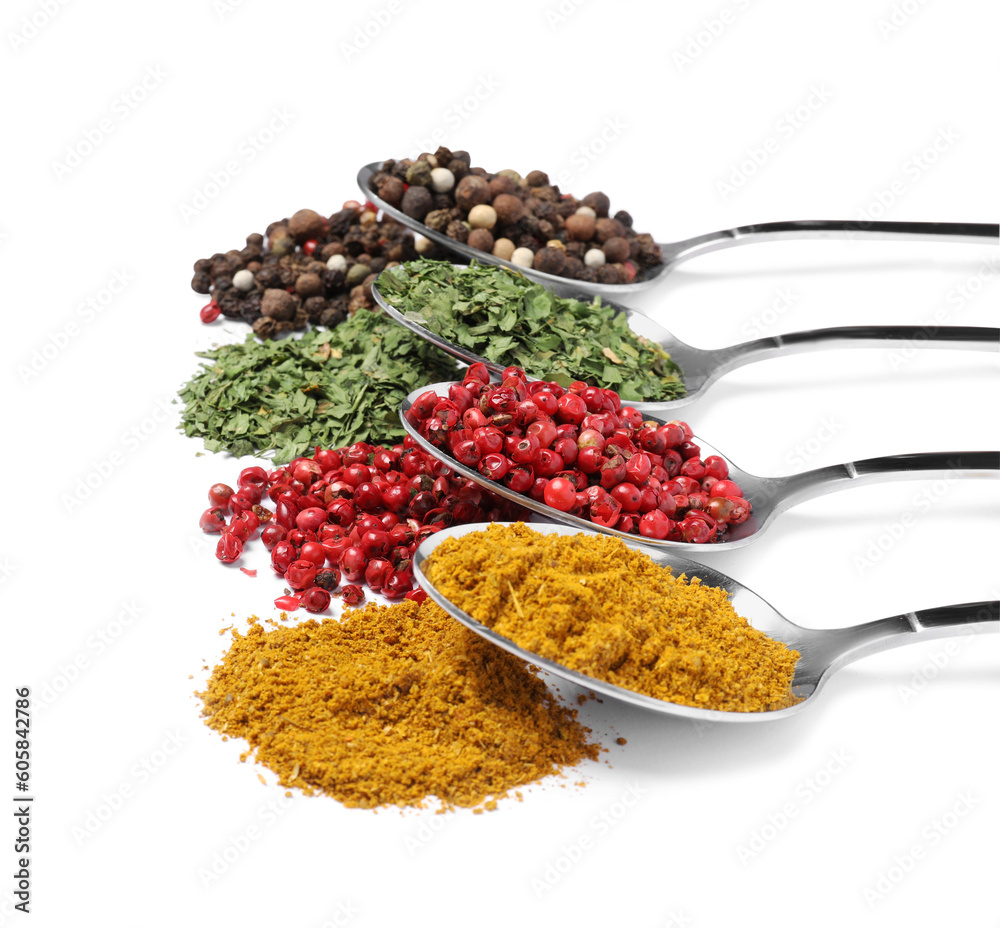 Metal spoons with different spices on white background Metal spoons with different spices on white background