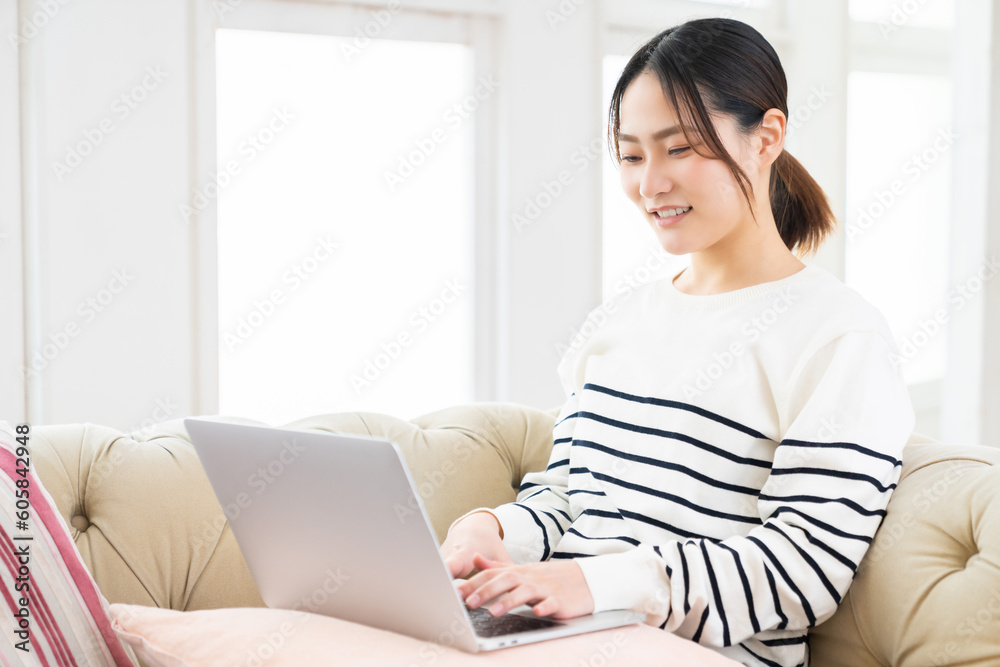 部屋でラップトップコンピューターを見る女性 部屋でラップトップコンピューターを見る女性