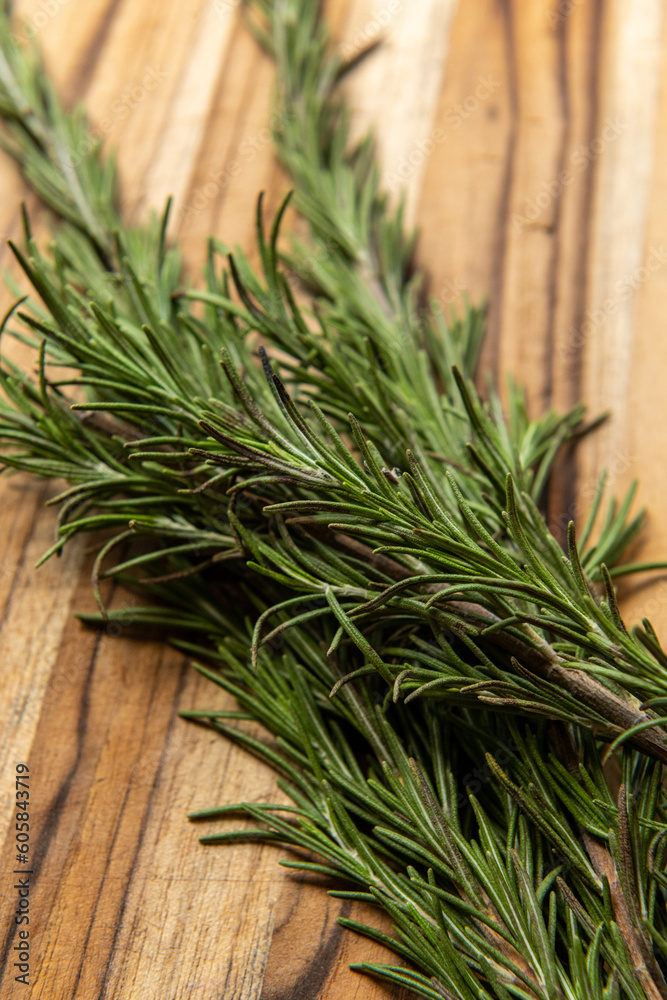 Fresh green rosemary on a wooden board organic bunch Fresh green rosemary on a wooden board organic bunch