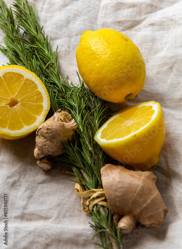 Fresh rosemary bunch ginger and lemon on a natural linen cloth for a healthy detox