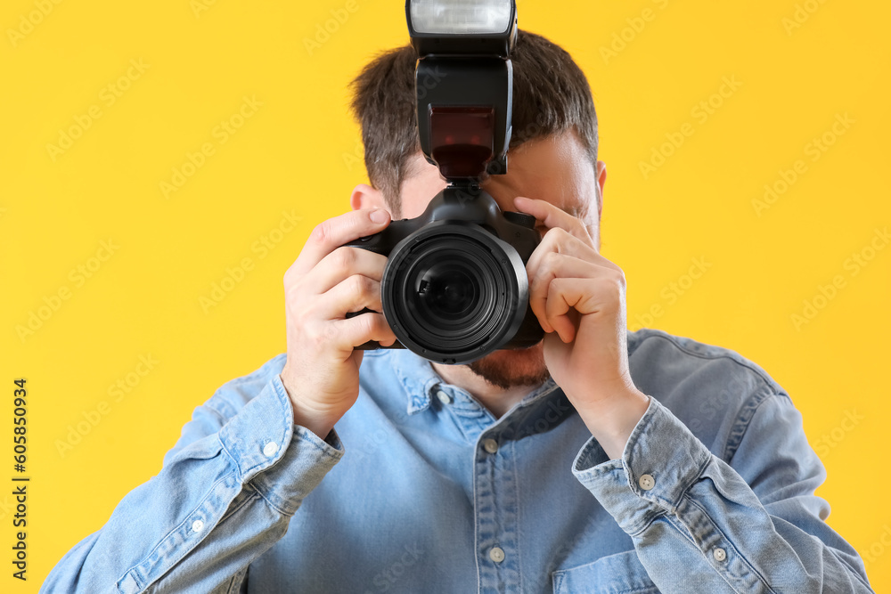 Male photographer with professional camera on yellow background, closeup Male photographer with professional camera on yellow background, closeup