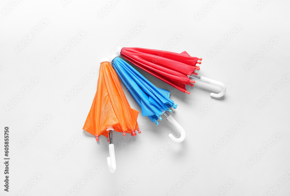 Different mini umbrellas on white background