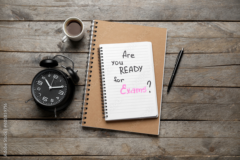 Notebooks with question ARE YOU READY FOR EXAM?, cup of coffee and alarm clock on brown wooden background Notebooks with question ARE YOU READY FOR EXAM?, cup of coffee and alarm clock on brown wooden background