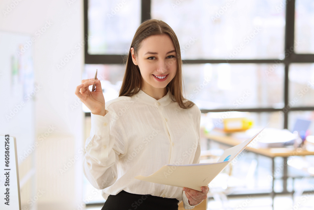 Young woman smiles holding investigation papers and pen Young woman smiles holding investigation papers and pen