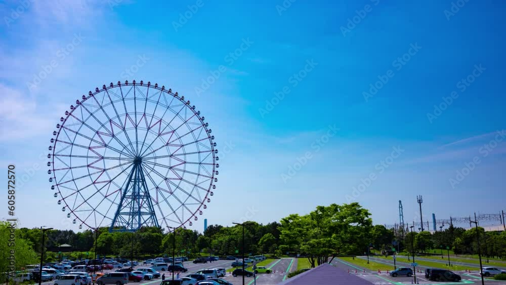 A timelapse of moving ferris wheel at the park behind the blue sky wide shot tilt A timelapse of moving ferris wheel at the park behind the blue sky wide shot tilt