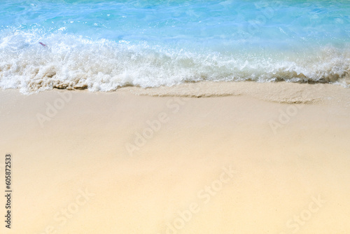 beach sand background for summer vacation concept. Beach nature and summer seawater with sunlight light sandy beach Sparkling sea water contrast with the blue sky.