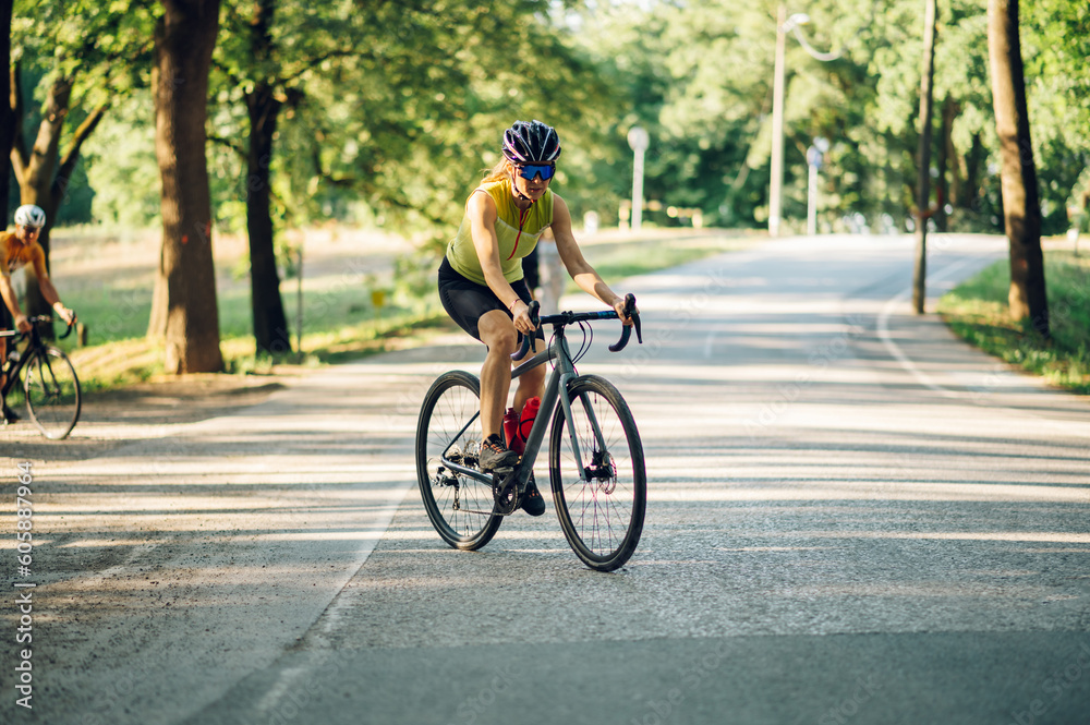 Portrait of a woman riding a bike during a sport cycling race on a sunset