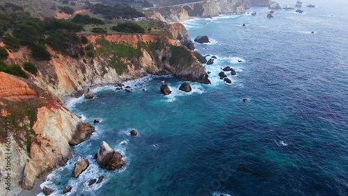 Aerial Cinematic drone coastline Big Sur Rock Creek Bixby Bridge coastal Highway 1 vista point California sunrise sunset morning rugged deep blue ocean early spring forward pan up motion photo