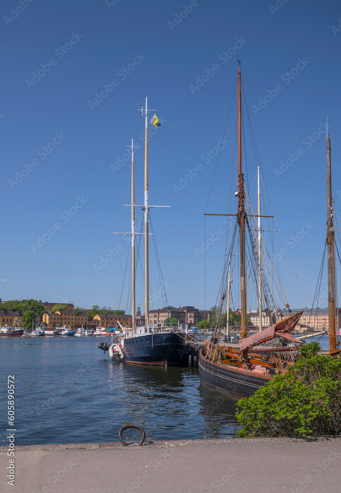 Old sailing boats at a pier in the bay Ladugårdslandsviken, a sunny summer day in Stockholm