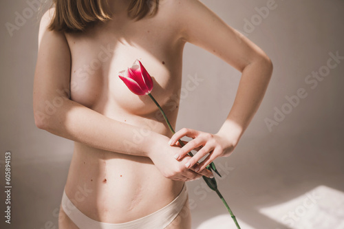 Photos Girl in underwear with red tulip close breasts