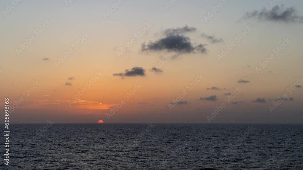 dramatic ocean sunset with colorful skyline, silhouetted clouds, and shimmering waves in slow motion dramatic ocean sunset with colorful skyline, silhouetted clouds, and shimmering waves in slow motion