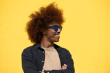 Happy and confident young man with arms crossed wearing sunglases