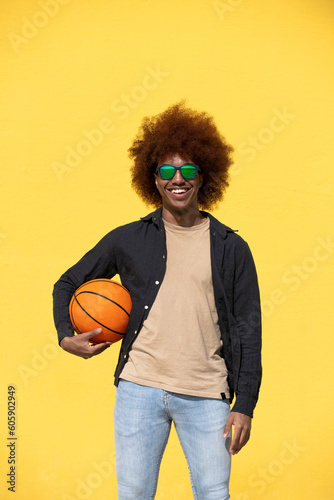 Portrait of a curly hair man holding a basket ball