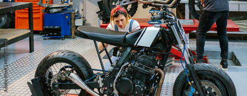 Canvastavla Female mechanic checking custom motorcycle on garage
