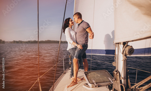 Romantic couple on yacht at sunset, Young couple relaxing on the yacht cruise. Travel adventure, yachting vacation. © VlaDee
