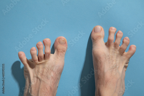 Male barefoot on the blue background.